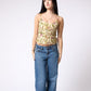 Woman wearing a floral top and blue jeans on a white background