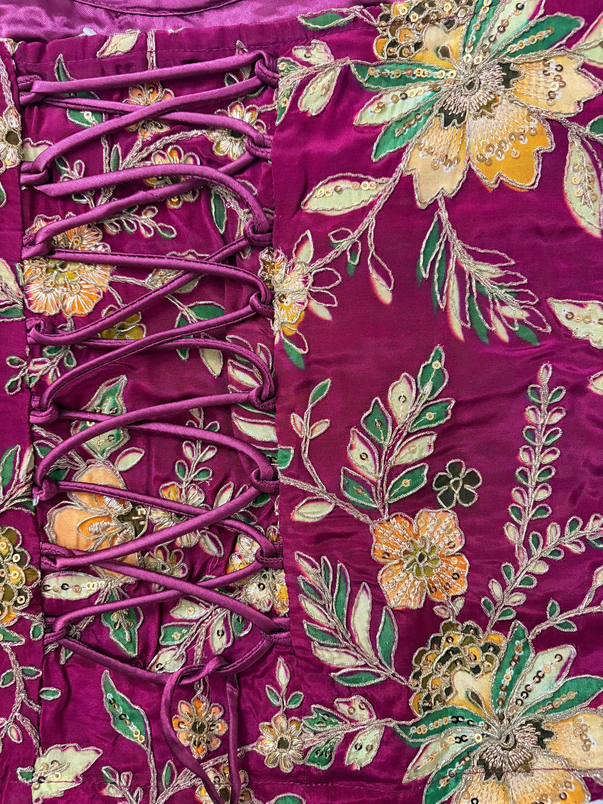 Close-up of a purple fabric with floral embroidery and lace details