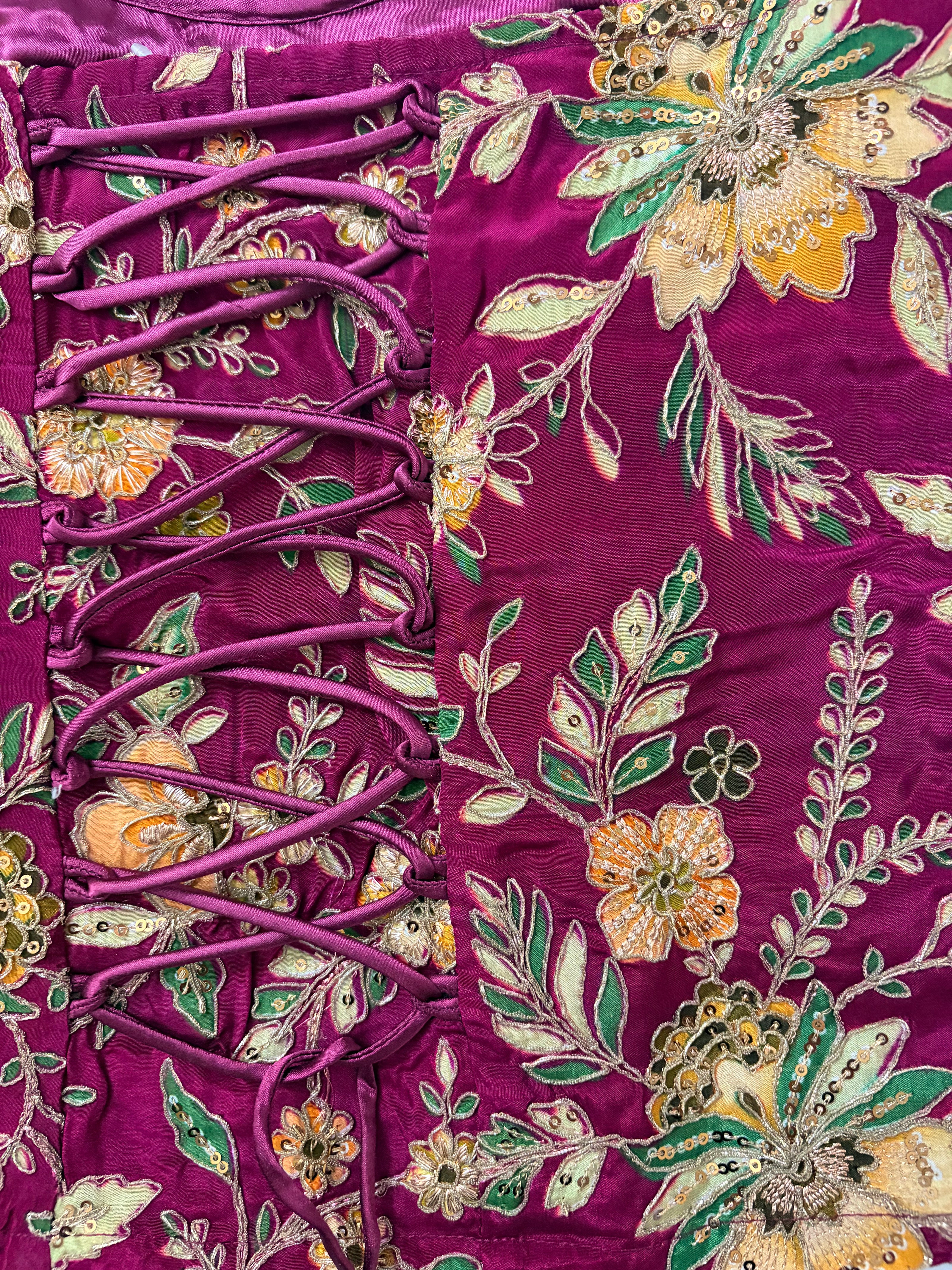 Close-up of a purple fabric with floral embroidery and lace details