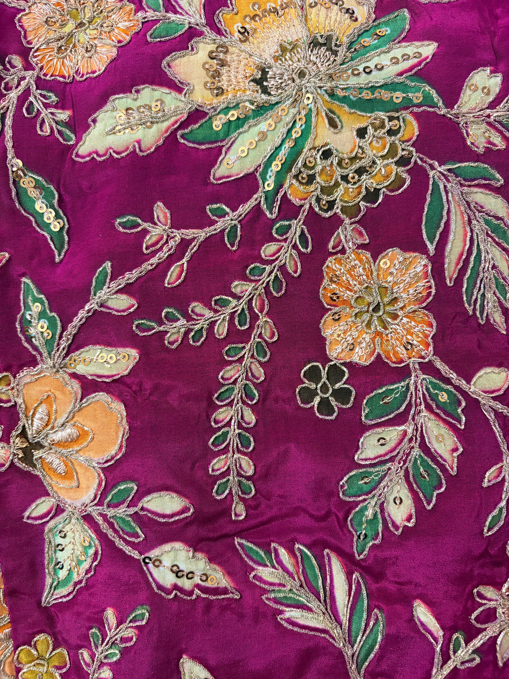 Close-up of floral embroidery on a purple fabric
